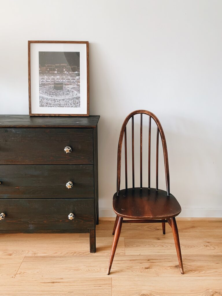 Szafka z ciemnego drewna i krzesło vintage
